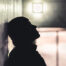A man is leaning against a wall