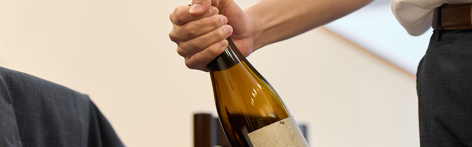 A man holds a bottle of wine in his hands