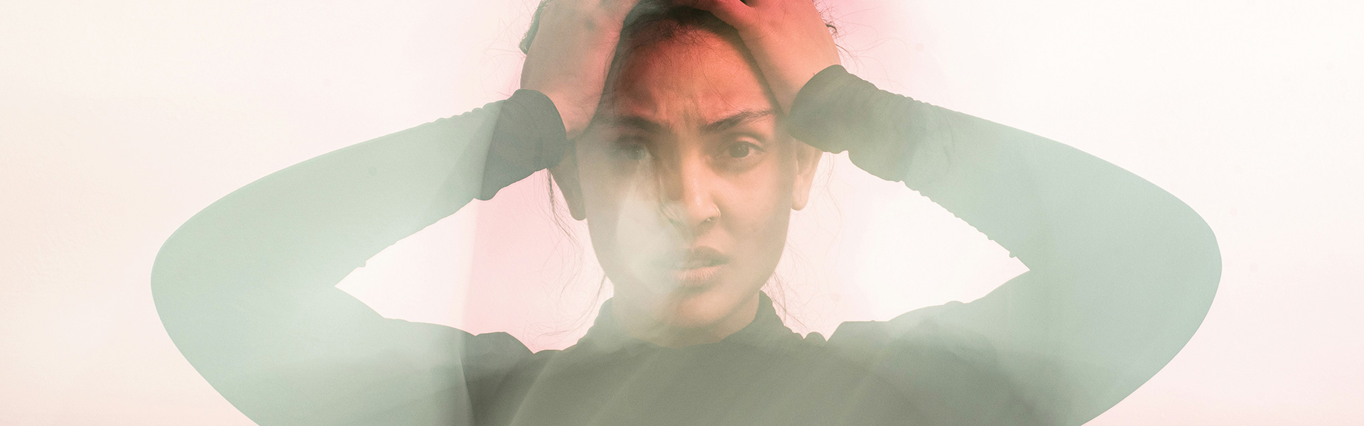 A blurry image of a girl holding her head