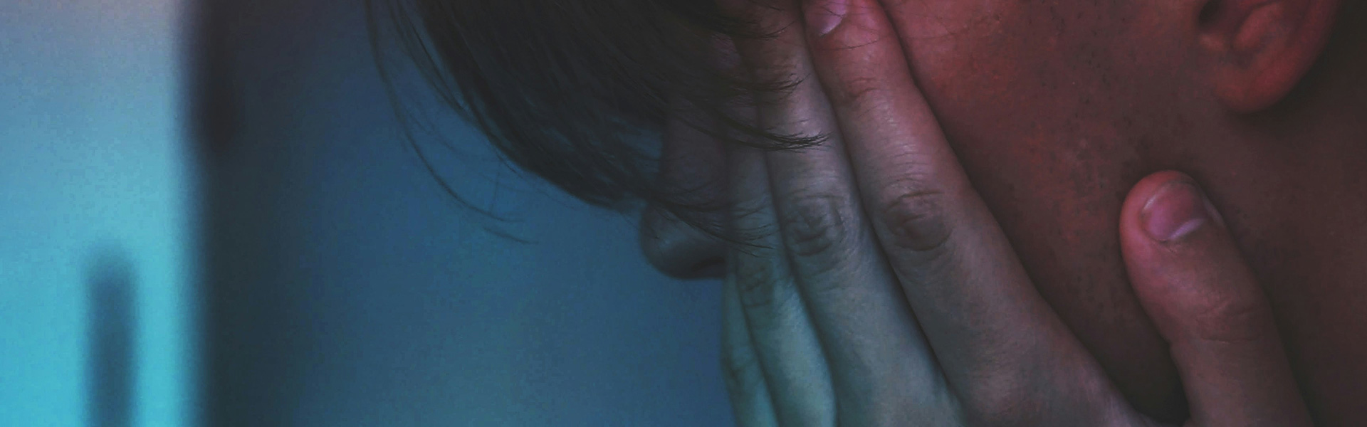 The man with the bent head covered his face with his hands