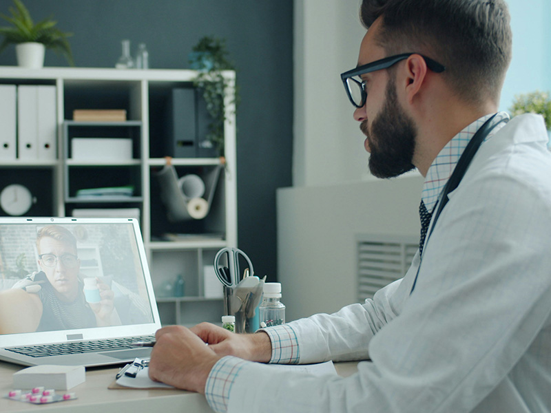 the doctor talks via video link with the patient via laptop